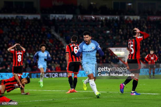Sergio Aguero of Manchester City celebrates after sliding in next to Tyrone Mings of Bournemouth to score his team's second goal during the Premier...