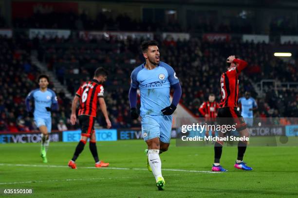 Sergio Aguero of Manchester City celebrates after sliding in next to Tyrone Mings of Bournemouth to score his team's second goal during the Premier...