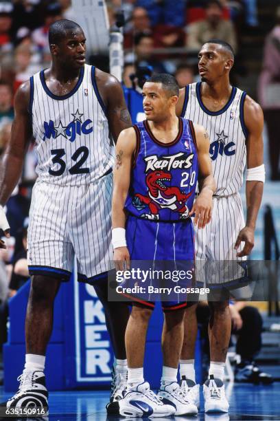 Anfernee Hardaway and Shaquille O'Neal of the Orlando Magic looks on against Damon Stoudamire of the Toronto Raptors on January 3, 1996 at the...