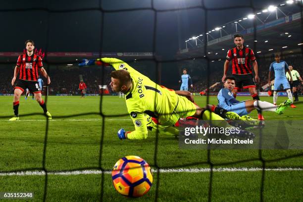 Sergio Aguero of Manchester City slides in next to Tyrone Mings of Bournemouth to score his team's second goal past Artur Boruc of Bournemouth during...