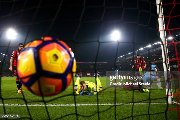 Sergio Aguero of Manchester City slides in next to Tyrone Mings of Bournemouth to score his team's second goal past Artur Boruc of Bournemouth during...
