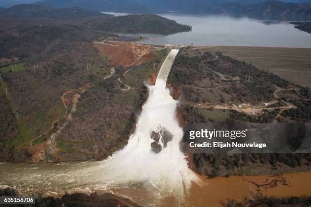 Oroville lake, the emergency spillway, and the damaged main spillway, are seen from the air on February 13, 2017 in Oroville, California. Almost...
