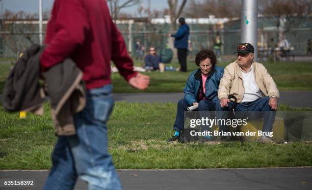 Oroville evacuees Bill O'Kelley and his wife Doris O'Kelley sit near a flagpole on the grounds of the Silver Dollar Fair evacuation shelter in Chico,...