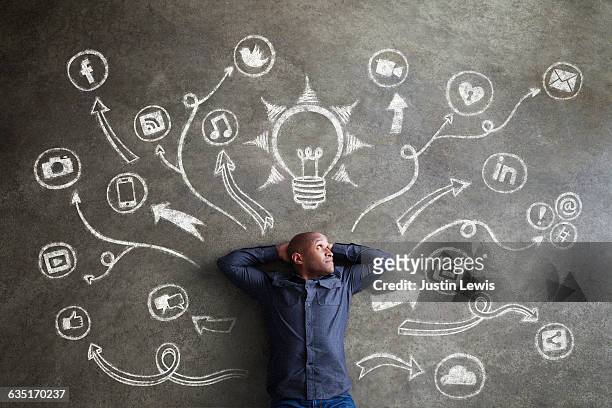 african man, 30s, surrounded by chalkboard symbols - idea foto e immagini stock