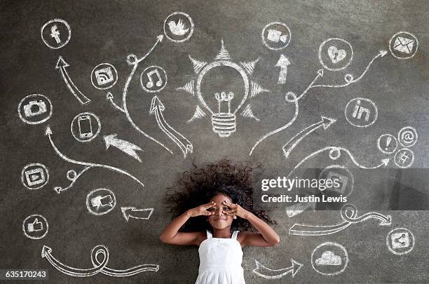 african girl surrounded by chalk tech symbols - lying on back photos stock pictures, royalty-free photos & images