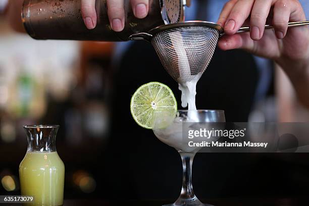 bartender pouring a cocktail - bartender mixing drinks stock-fotos und bilder