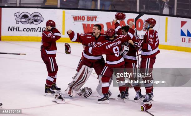 Merrick Madsen of the Harvard Crimson celebrates with teammates after beating the Boston University Terriers during NCAA hockey in the championship...