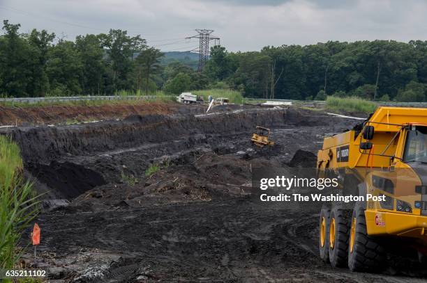 Heavy machinery excavate and carry coal ash from drained coal ash pond E at Possum Point Power Station in Dumfries, Va. On June 26, 2015. Dominion...