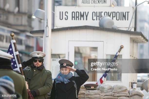 Tourists are seen having their picture taken on a cold morning on 13 February, 2017 at checkpoint Charlie where formerly the border between the...