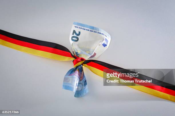 Berlin, Germany In this Photo Illustration a 20 Euro bill is wrapped round with a ribbon in the national colors of Germany on February 14, 2017 in...