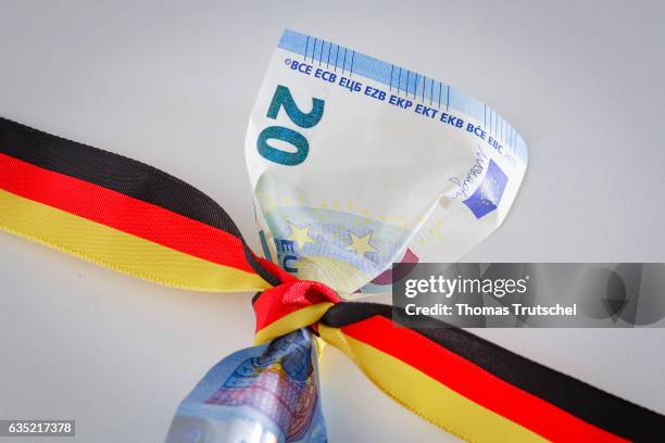 Berlin, Germany In this Photo Illustration a 20 Euro bill is wrapped round with a ribbon in the national colors of Germany on February 14, 2017 in...