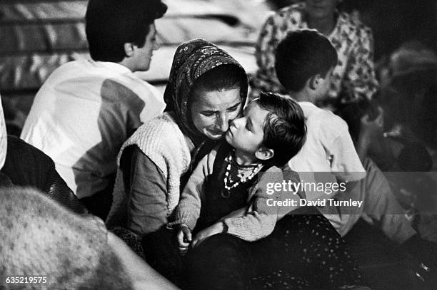 Little girl and her grieving mother sit close together in a Muslim refugee shelter at Zenica, after receiving news that the girl's father was one of...