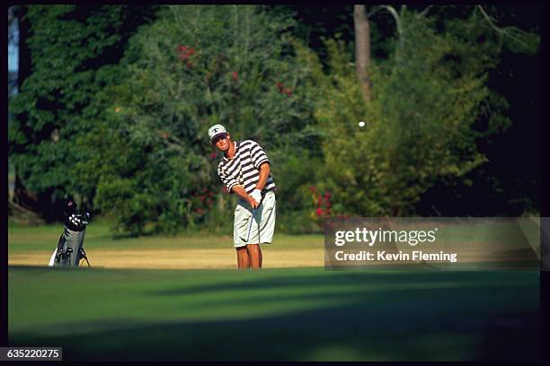 Golfer watches his ball fly in the air after hitting it. Golf Course on Jekyll Island, Georgia, USA.