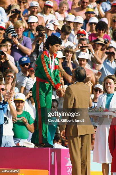 Nawal el Moutawakel of Morocco receiving her gold medal on the podium of the women's 400-meter hurdles at the 1984 Olympic Games. She becomes the...