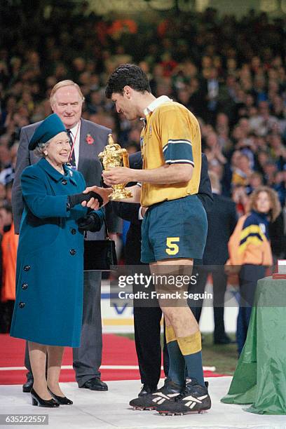 Britain's Queen Elizabeth presents Australia's captain John Eales with the William Webb Ellis trophy. Australia beat France in the Rugby Union World...