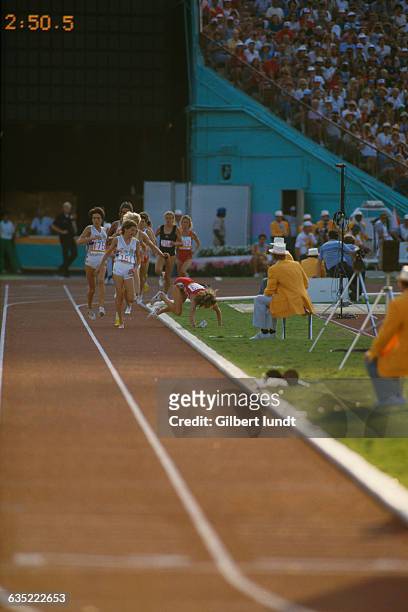 South African runner Zola Budd watches her chief competitor, American Mary Decker, fall to the ground in the final of the Women's 3,000-meter run at...