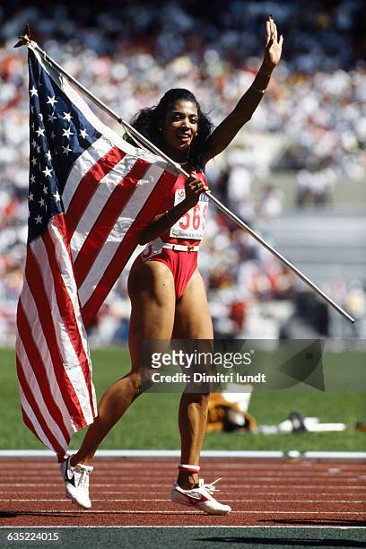 Florence "FloJo" Griffith Joyner carries the American flag around the track at the Olympic stadium in Seoul following her 100-meter dash victory in...