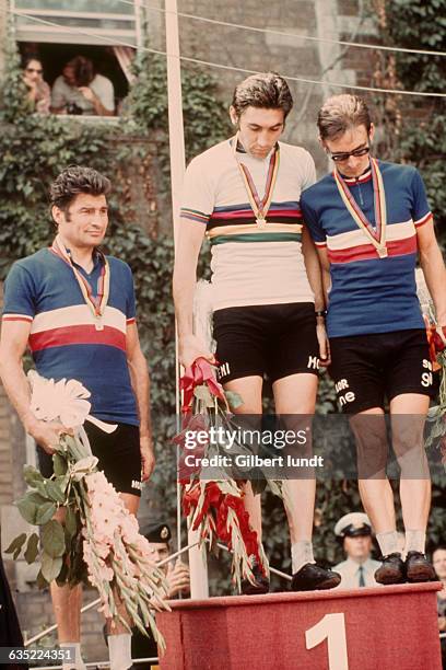 Podium of the 1974 World Road Cycling Championships. Raymond Poulidor from France , Eddy Merckx from Belgium and Mariano Martinez from France .