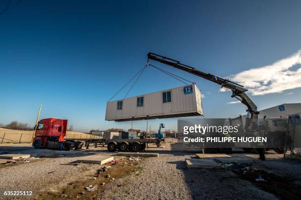 Workers use a crane to dismantle the "Provisional Reception Center" , containers installed by the government to house up to 1500 migrants, at the...