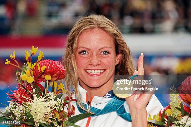 Dutchman Inge de Bruijn shows off the gold medal she won in the women's 100-meter butterfly final at the Sydney Olympics.
