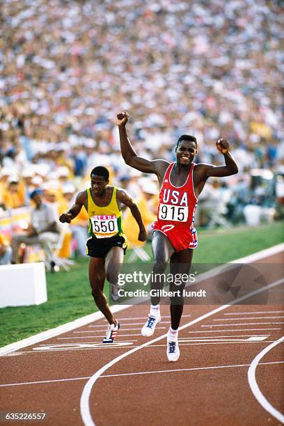 Carl Lewis, at the finish line, thrills a crowd of 92,000 spectators as he wins the gold medal in the men's 100-meter sprint, putting himself on...