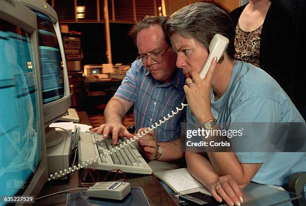 Larry Webster and Jill Tarter watch computer screens at the radio observatory in Arecibo, Puerto Rico. They are working on the beginning of a search...