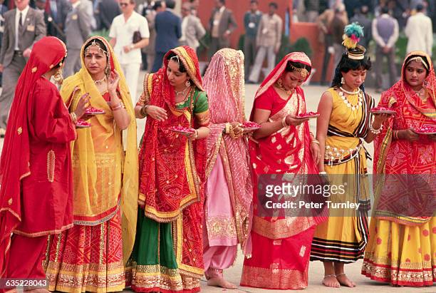 Women in brightly colored saris, and bearing trays of flower petals, wait to greet Mikhail Gorbachev, in India on a state visit.