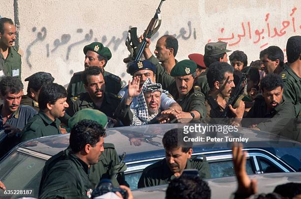 Yasser Arafat, leader of the Palestine Liberation Organization, waves to a crowd at the Jabaliya camp where the Intifada began.