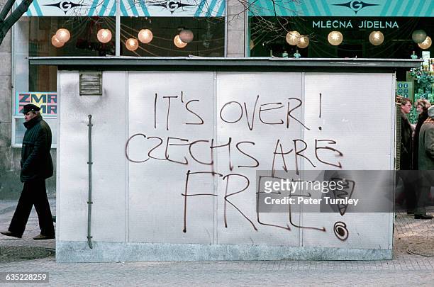 Graffiti reading "It's over! Czechs are free!" adorns a building in Prague during the Velvet Revolution.