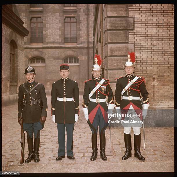 Four members of the Republican Guard model the various Guard uniforms in the courtyard of the Elysee Palace. Paris, France.