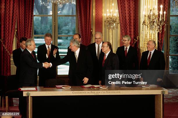 Serbian President Slobodan Milosevic shakes hands with Croat President Franjo Tudjman as Bosnian President Alija Izetbegovic watches, just after the...