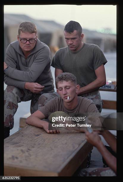 Few American soldiers play a game of cards on Christmas day in Saudi Arabia. They are part of a U.S.-led coalition preparing to liberate...