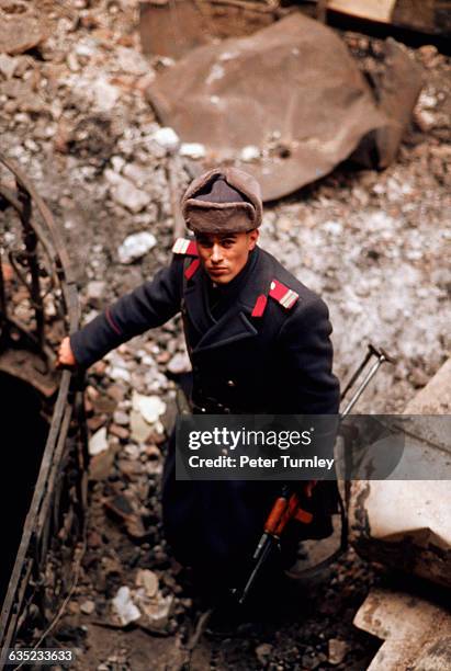 Romanian soldier amid the rubble of Bucharest's university library, which was destroyed during the December 1989 revolution.