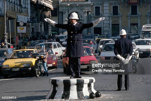 Two traffic officers direct traffic around Piazza Venetia.