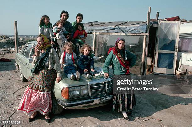 Rom family sits outside at a Sardinian shantytown.