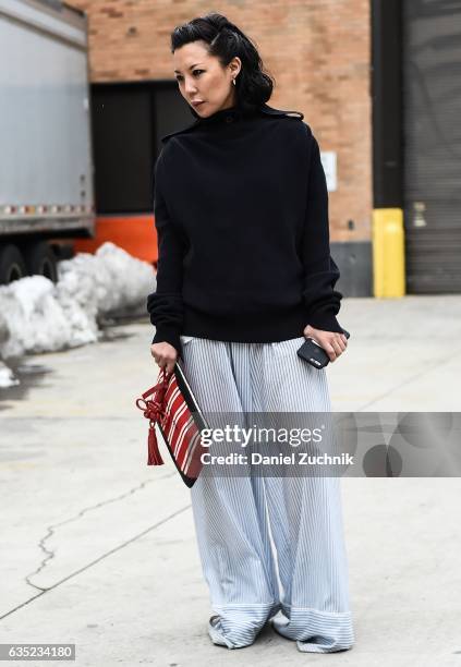 Jeannie Lee is seen wearing a black sweater, blue striped pants and red and white striped bag outside of the Proenza Schouler show during New York...