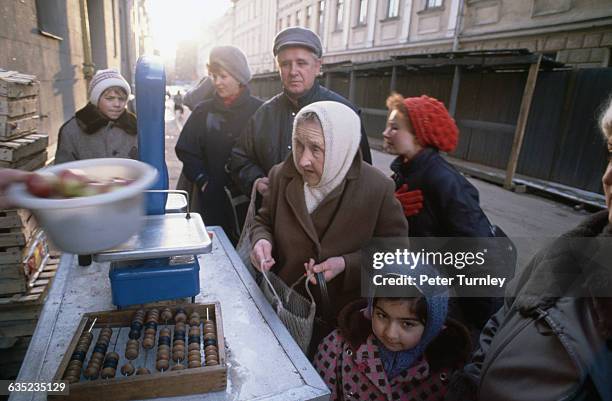 Russians wait in line to buy apples from a street vendor in Moscow.