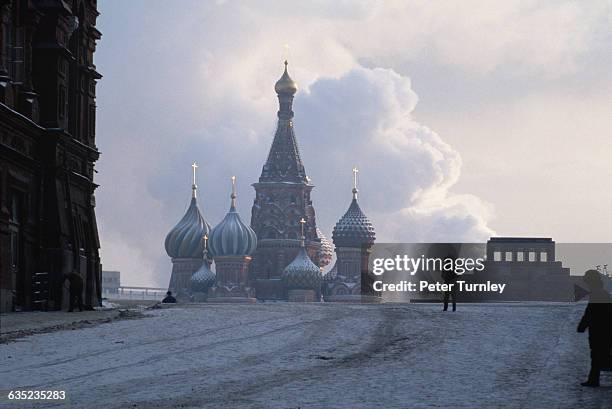 Two men stroll across the a snow covered Red Square near Lenin's tomb and St. Basil Cathedral in Moscow.