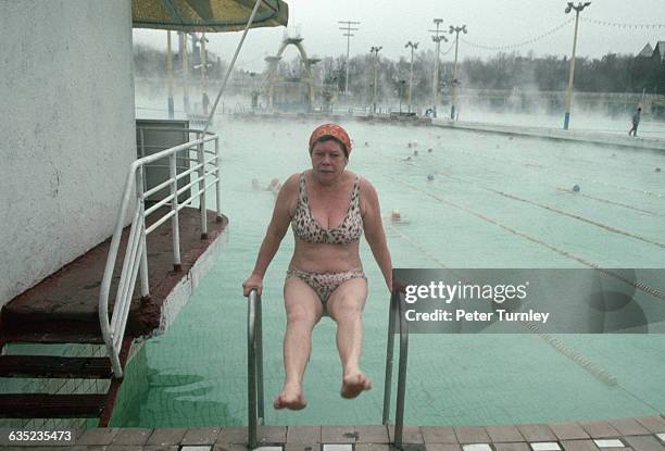 Swimmer Holding onto Swimming Pool Handrails