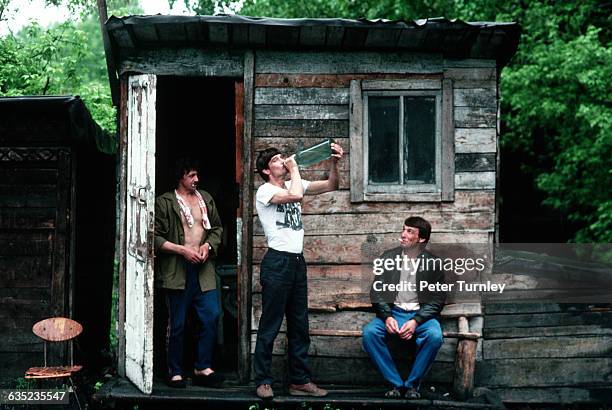 Few Siberian men relax outside a shack in a poor coal-mining and steel-manufacturing town. Their community has been hit hard by widespread economic...