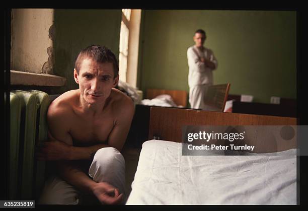 Mental Patient Crouching near Space Heater