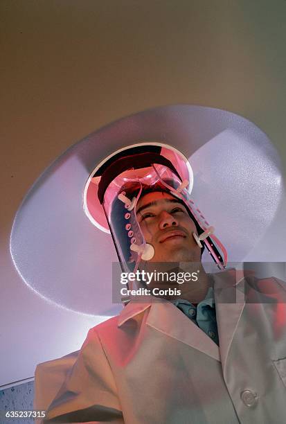 Man lies with his head inside a Positron Emission Tomography scanner. The PET is used to take brain scans.