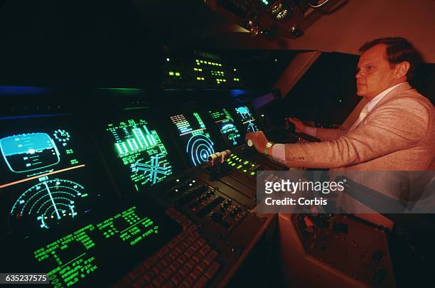 S Bob Shiner "flies" in the test cockpit of a sophisticated flight simulator for the Orient Express, a hypersonic airplane still in development which...