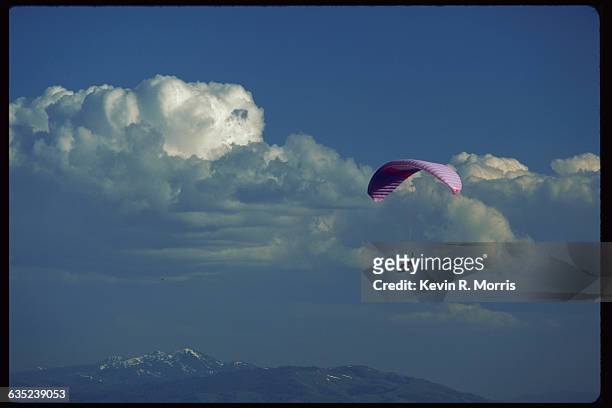 Paraglider floats in the sky above the Grand Teton Mountains in Jackson Hole Ski Resort in Bridger-Teton National Forest, Wyoming, USA. | Location:...
