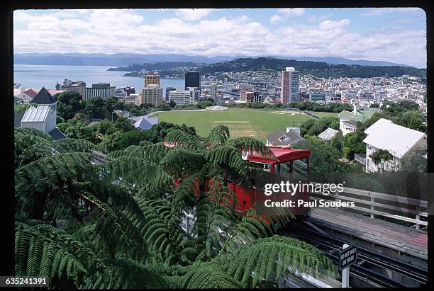 Cable car climbs the hill to the city's Kelburn district. Below them lies the built up urban sprawl and city harbor. | Location: Kelburn, Wellington,...