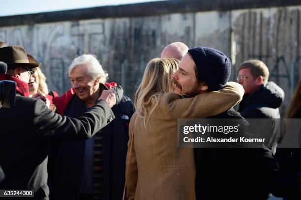 Berlinale director Dieter Kosslick greets festival director Paul Verhoeven with actress Sienna Miller and Daniel Bruehl in front of the Berlin wall...