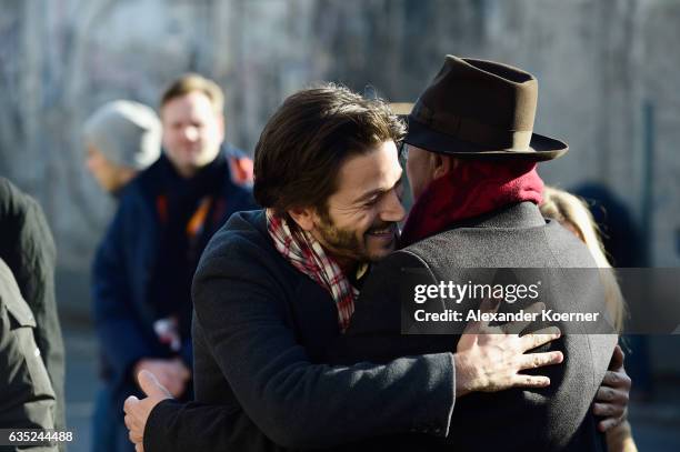 Berlinale director Dieter Kosslick greets actor Diego Luna in front of the Berlin wall in protest against barriers and walls in a simple gesture...