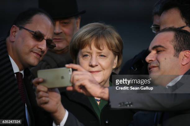 German Chancellor Angela Merkel allows Tunisian diplomats to shoot a selfie with her after she and Tunisian Prime Minister Youssef Chahed laid...
