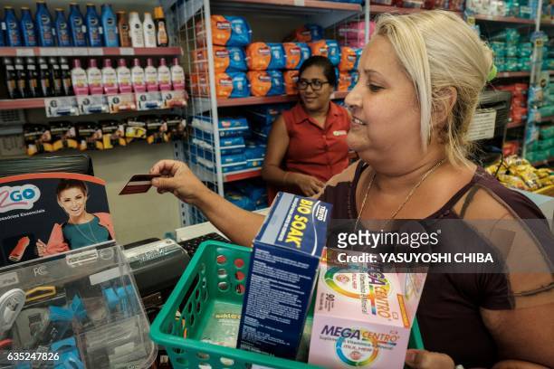 Woman uses her "Mumbuca" card at pharmacy in Marica, surburb of Rio de Janeiro, Brazil, on February 8, 2017. Mumbuca, the first virtual social...
