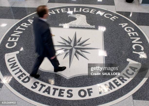 Man crosses the Central Intelligence Agency seal in the lobby of CIA Headquarters in Langley, Virginia, on August 14, 2008. AFP PHOTO/SAUL LOEB